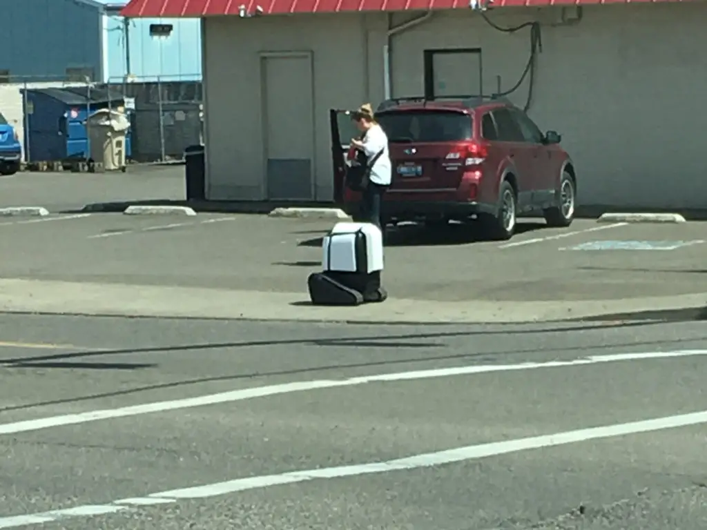 Philoamth delivery robot rolling down a sidewalk next to the local Dairy Queen
