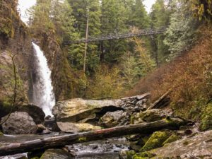Waterfall at Drift Creek Falls with suspension bridge in the background