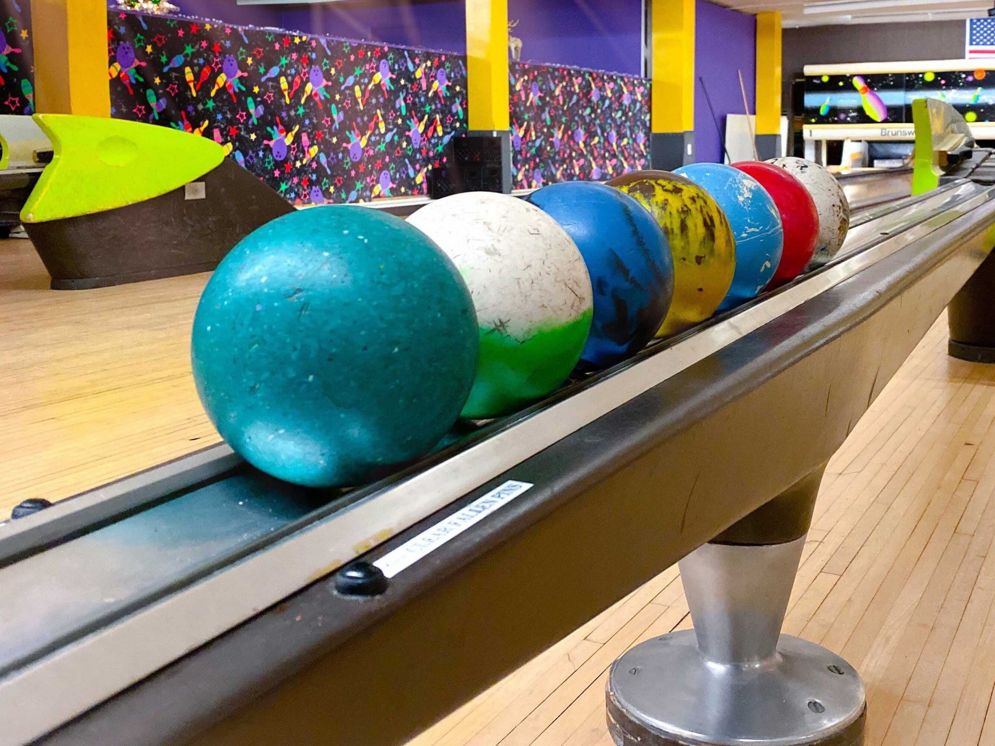 Duckpin Bowling balls in various colors, lined up and ready for use