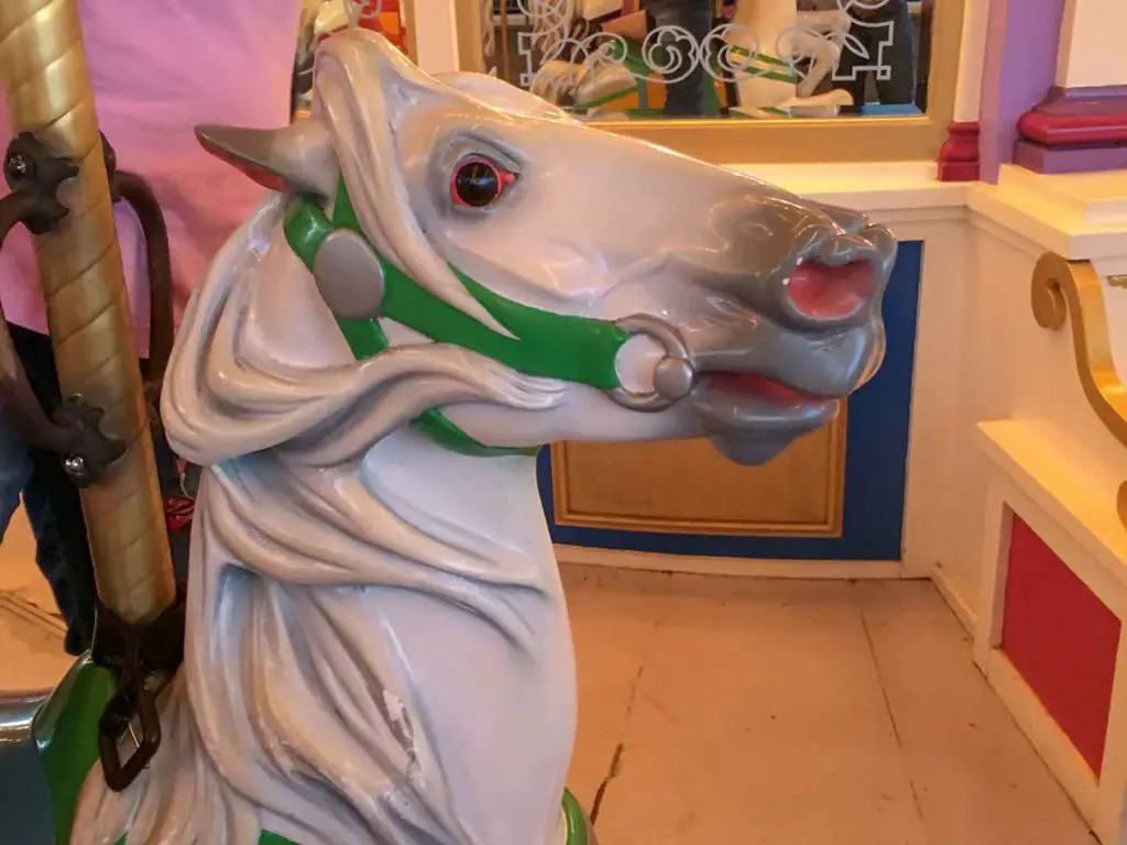 white carousel horse with green bridle on Cinderella's Carousel