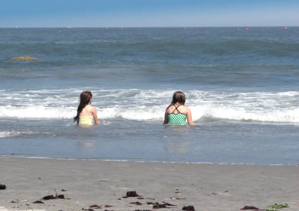 two girls sitting in the waves at Scarborough Beach Rhode Island