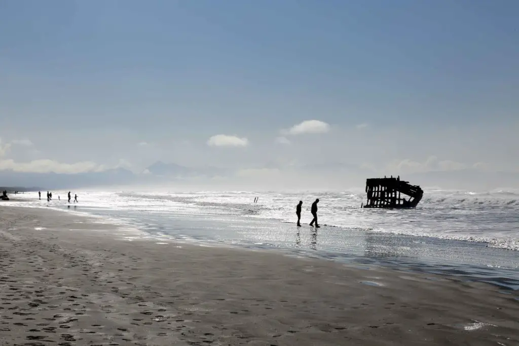 people walking in front of the Peter Iredale shipwreck