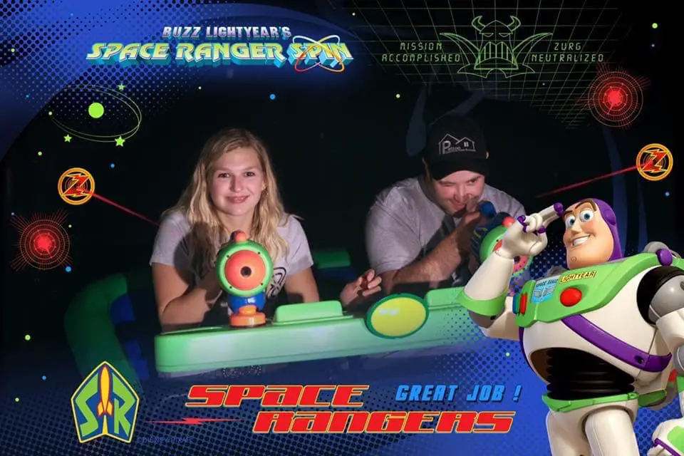 Man and woman playing Buzz Lightyear after entering the right through the Walt Disney World LIghtning Lane.