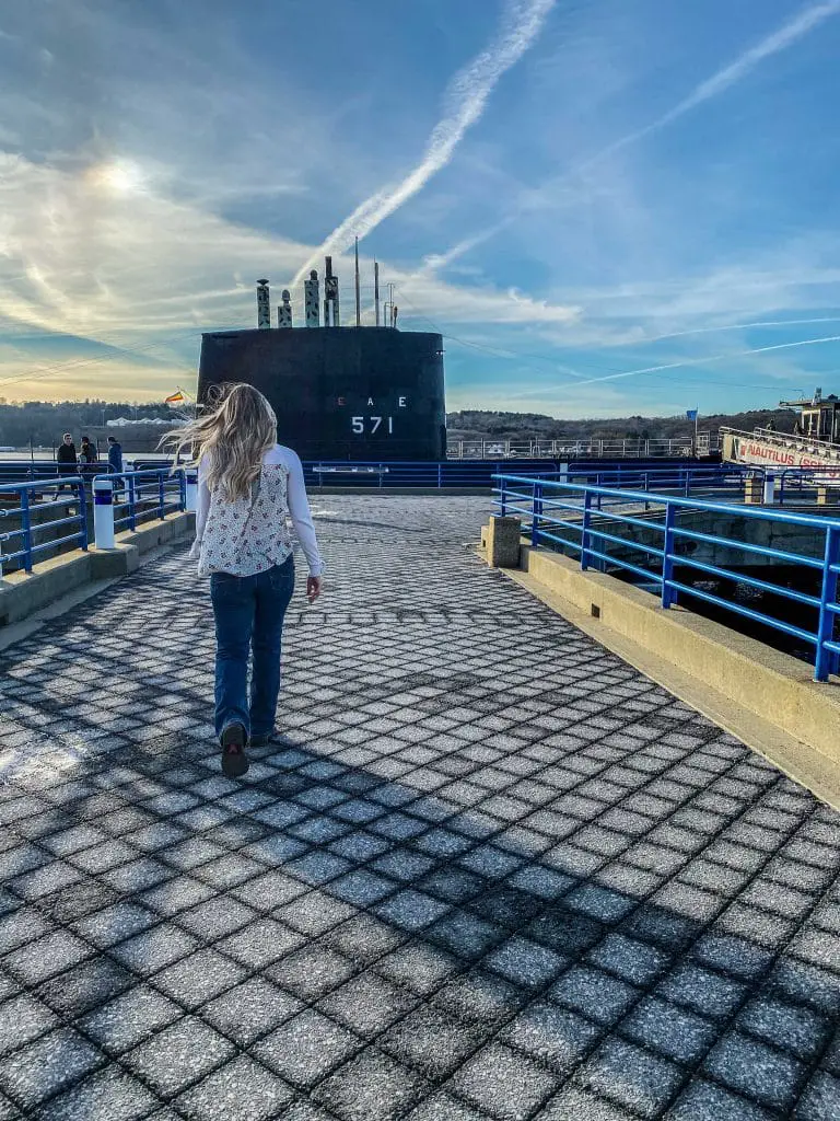 Young woman walks toward the USS Nautilus on a Connecticut winter activity at the Submarine Force Museum