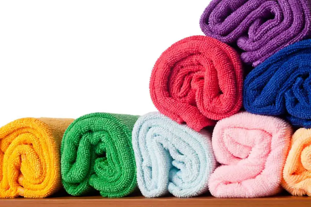 a stack of microfiber towels in multiple colors ready to be added to a dog gear travel bag