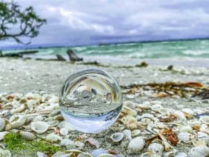 Lens ball on a bed of shells reflecting the ocean off Sanibel Island