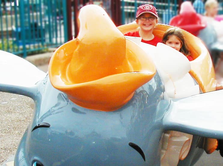 Young girls enjoy a ride on Dumbo during their first time at Disney World.