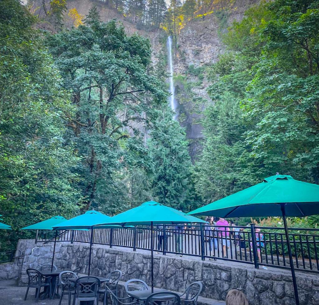 View of Multnomah Falls Oregon with green umbrellas in the foreground