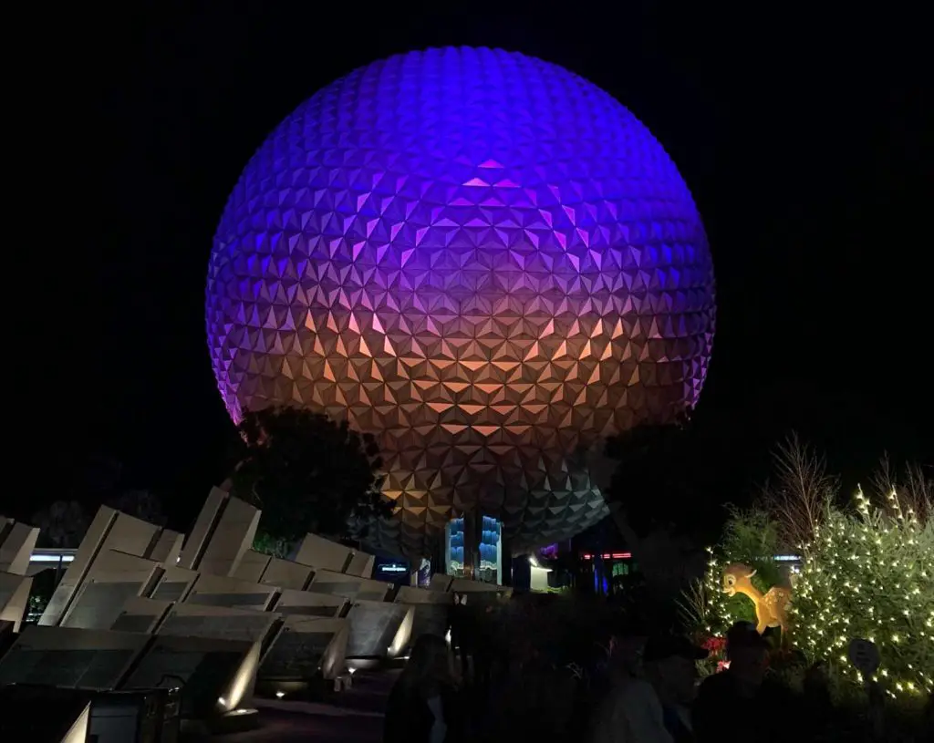 Epcot ball at night in purple hosting Extended Extra Magic Hours