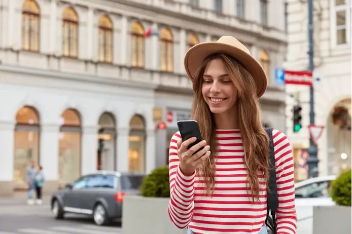 Woman looks at mobile phone while traveling.
