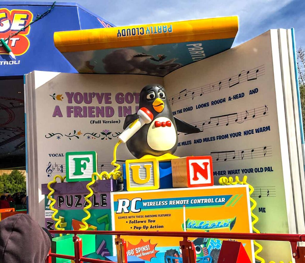 Wheezy penguin squeak toy holds microphone at the end of Slinky Dog Dash ride