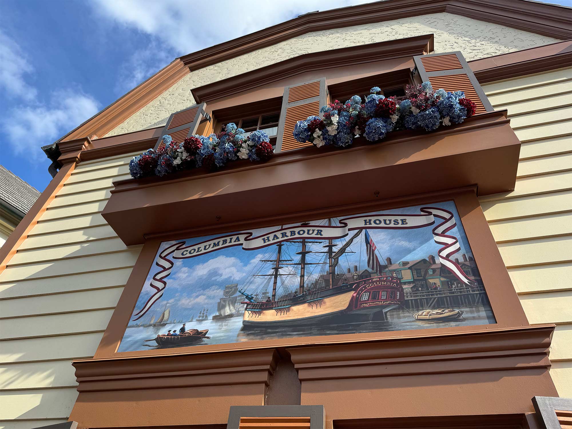 exterior of Columbia Harbour House restaurant, a beige and brown building in the early colonial American style.