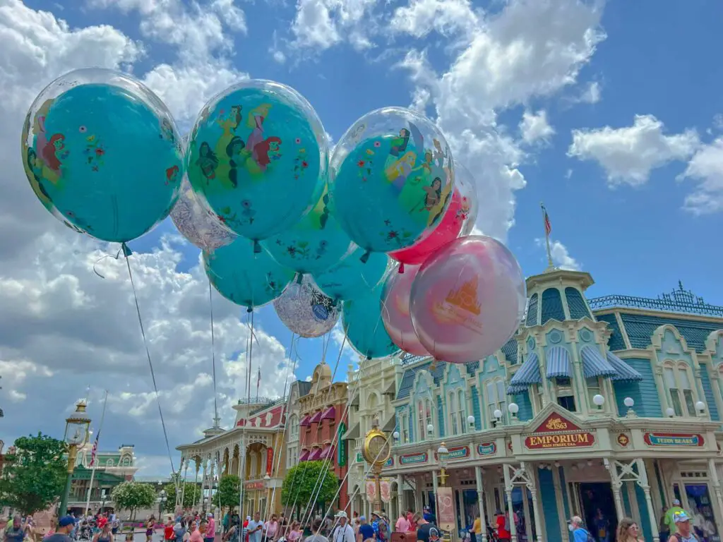 Disney themed balloons float in front of shops on Main Street USA at Disney World in spring
