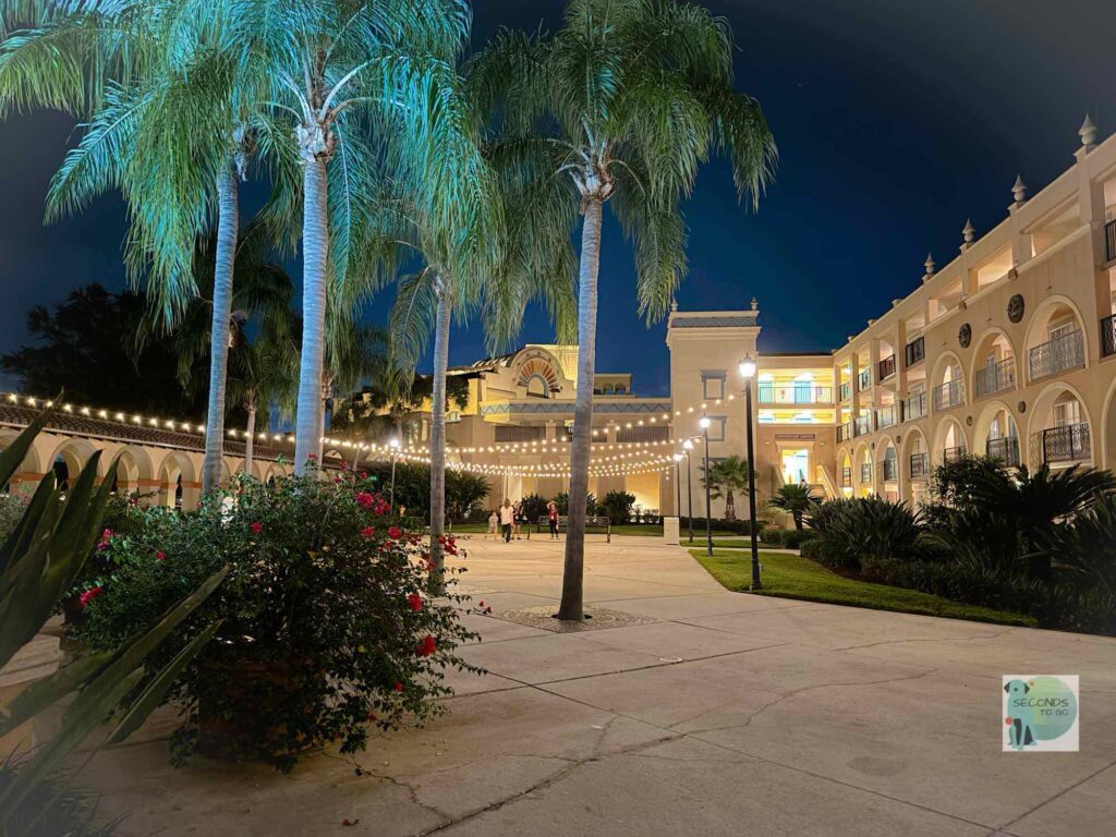 Exterior shot of Coronado Springs Disney World lit up under darkness.