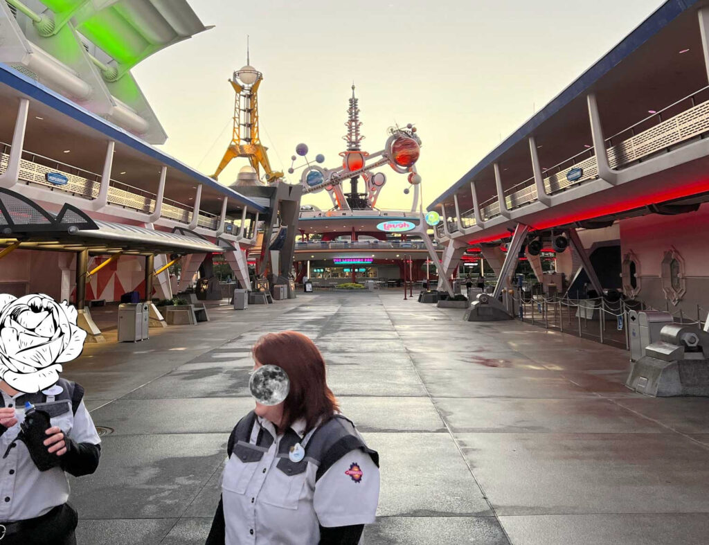 Cast members stand at a rope at the entrance to Tomorrowland at Disney World