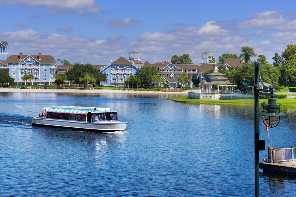 Boat sailing on Crescent Lake toward Disney Boardwalk Inn resort