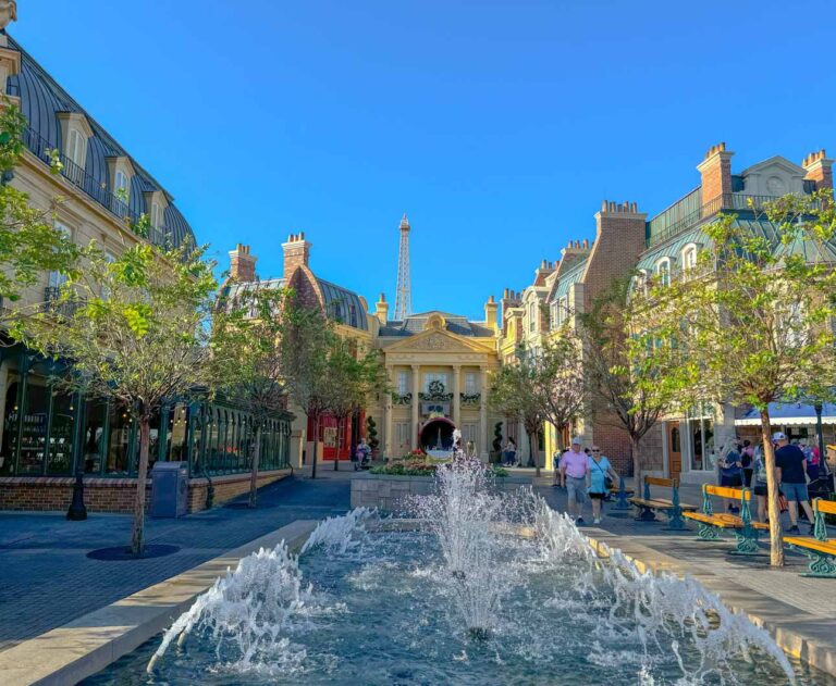 A beautiful fountain in front of French looking buildings located in Epcot World Showcase France pavilion.