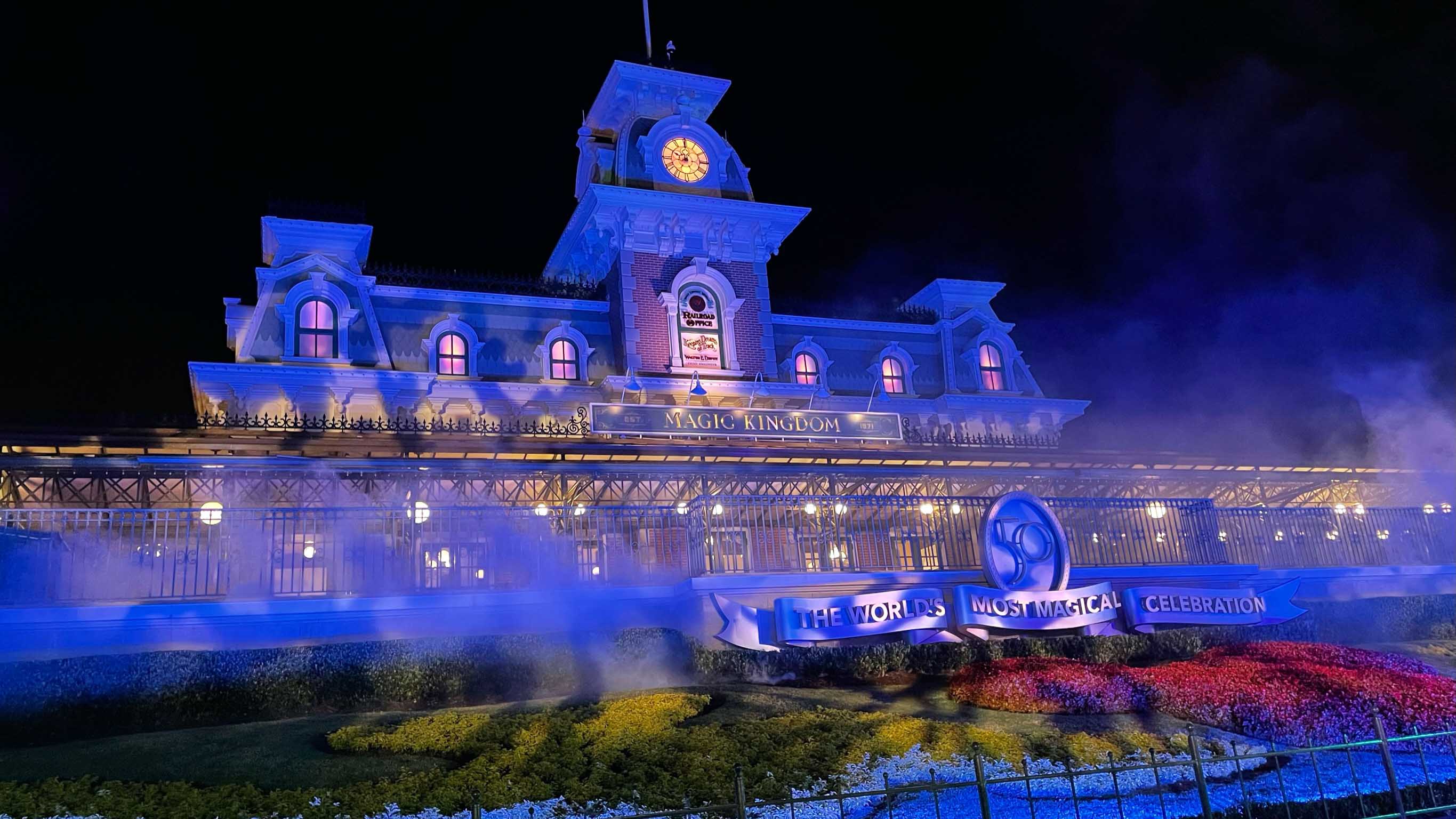 Magic Kingdom train station lit in purple light amidst fog for the Halloween holidays at Disney World