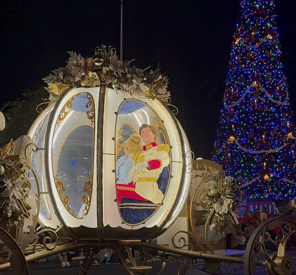 Cinderella and Prince Charming wave from fancy coach during Mickey's Very Merry Christmas Party parade.