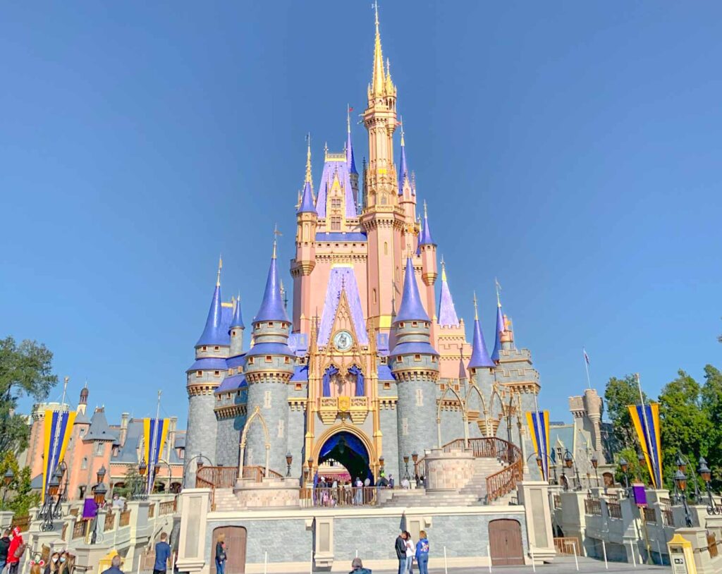 Disney World castle, pink and gray facade with purple spires.