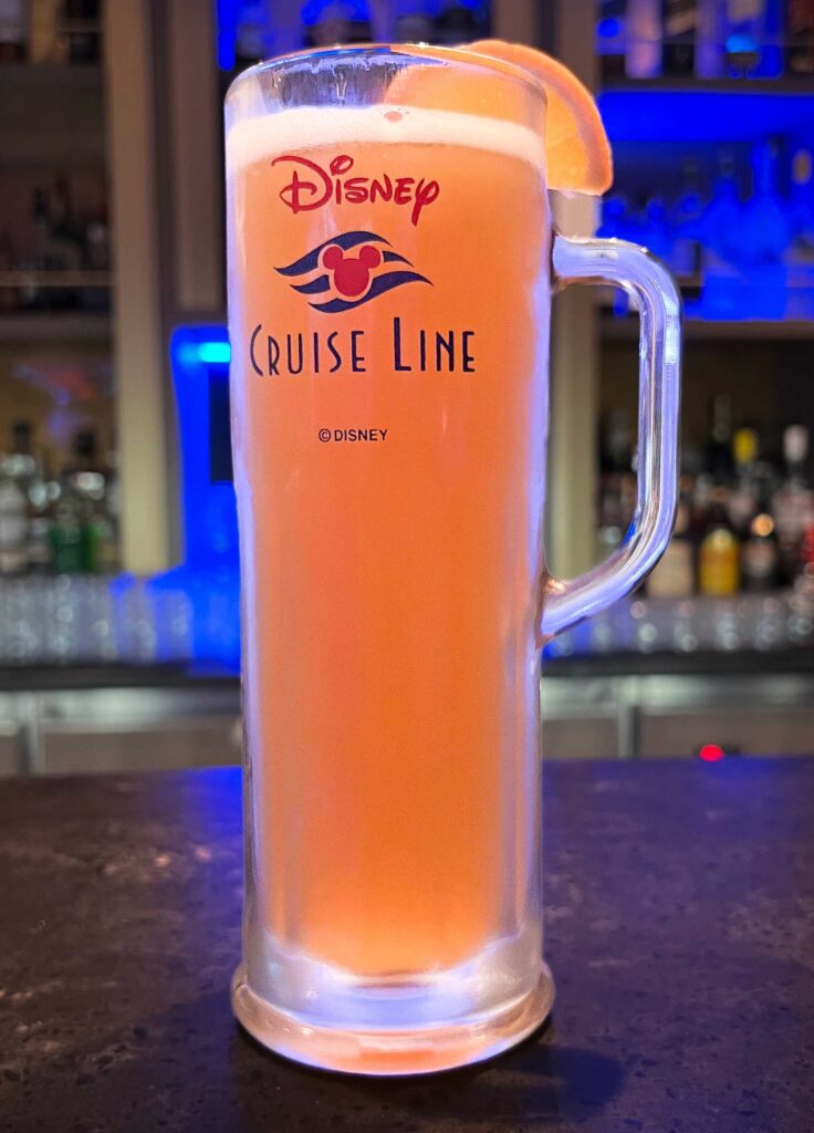 Disney Cruise Beer mug filled with Blue Moon Ale sits on bar top.