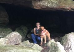 Travel blogger, Ali Patton, poses with mascot Nemo in a cave at Chatfield Hollow State Park in Connecticut