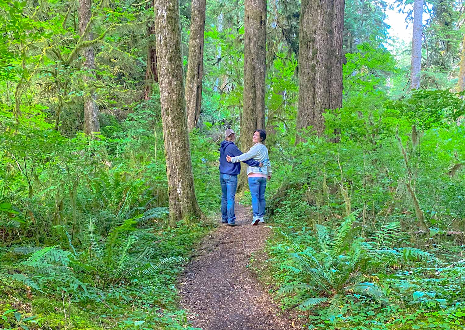 Mother-daughter travel blogger team enjoying an Oregon hiking trail through old growth forest