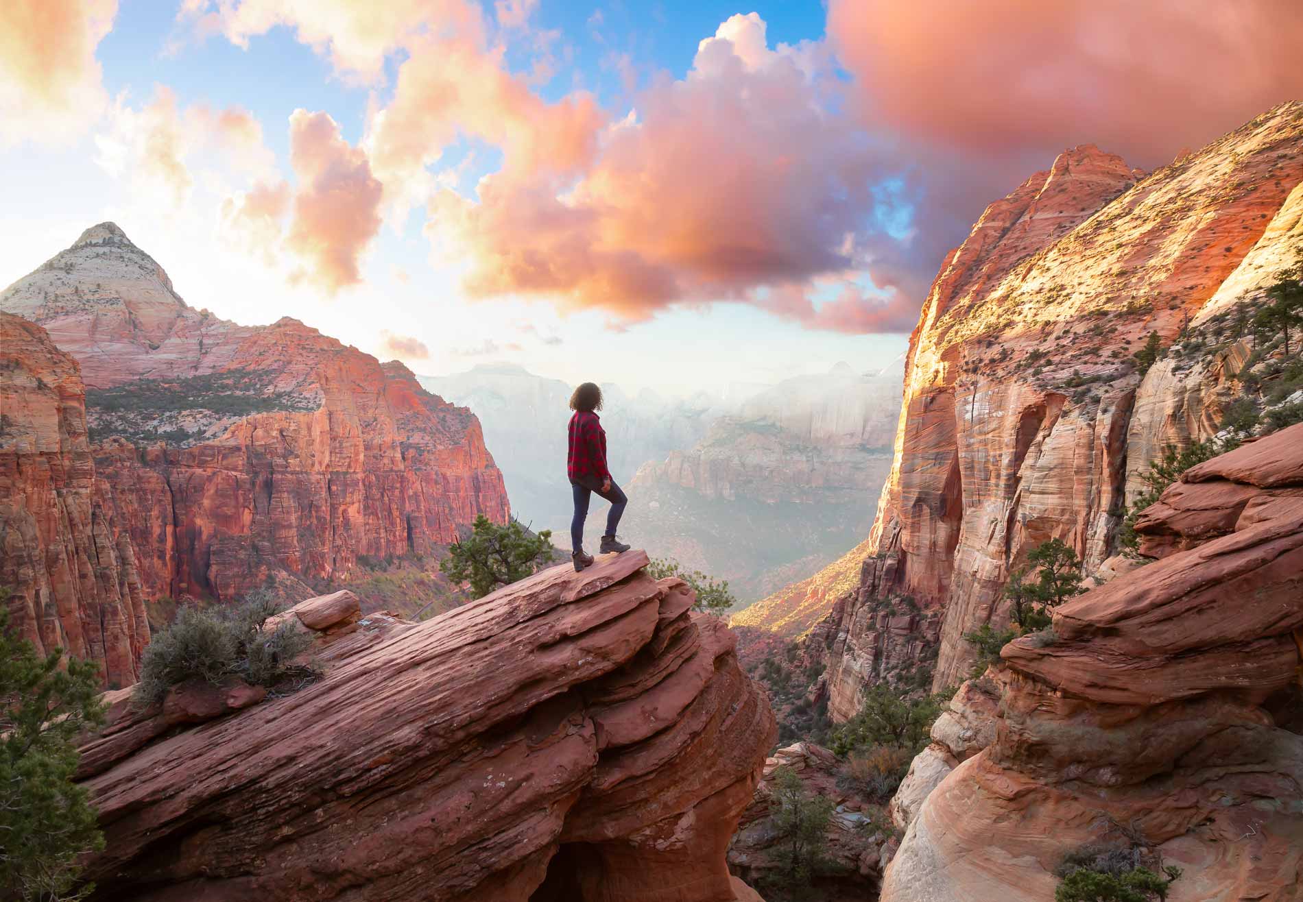 Woman standing on a rock outcrop overlooking a beautiful valley in the United States.